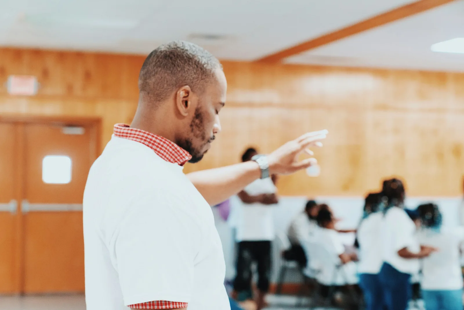 A facilitator leading a workshop, with participants engaged in the background