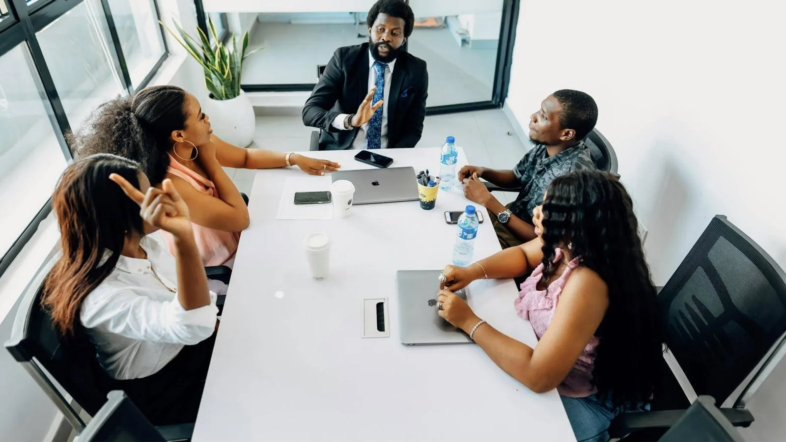A leadership team in discussion around a meeting table in a bright office