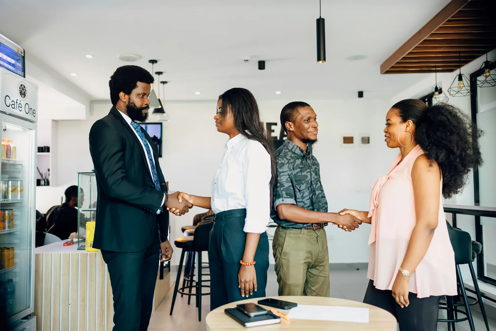 Colleagues greeting each other with handshakes in a modern office lobby