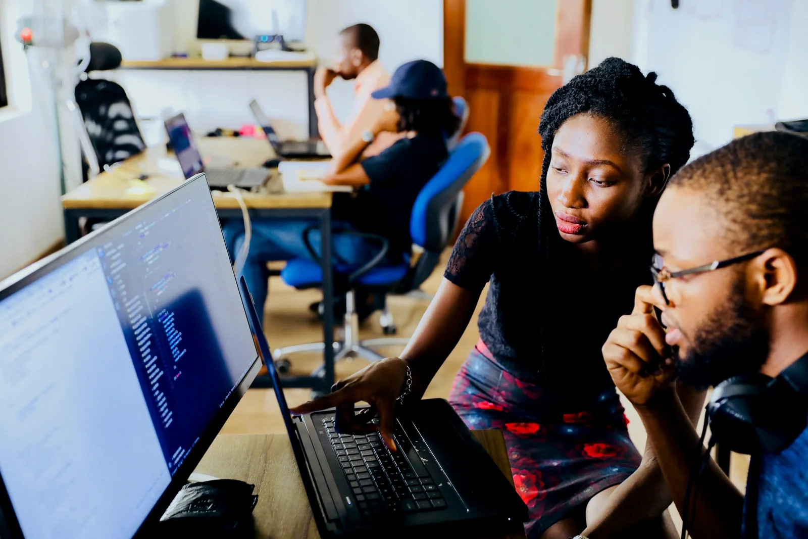 A team working together around laptops and a monitor